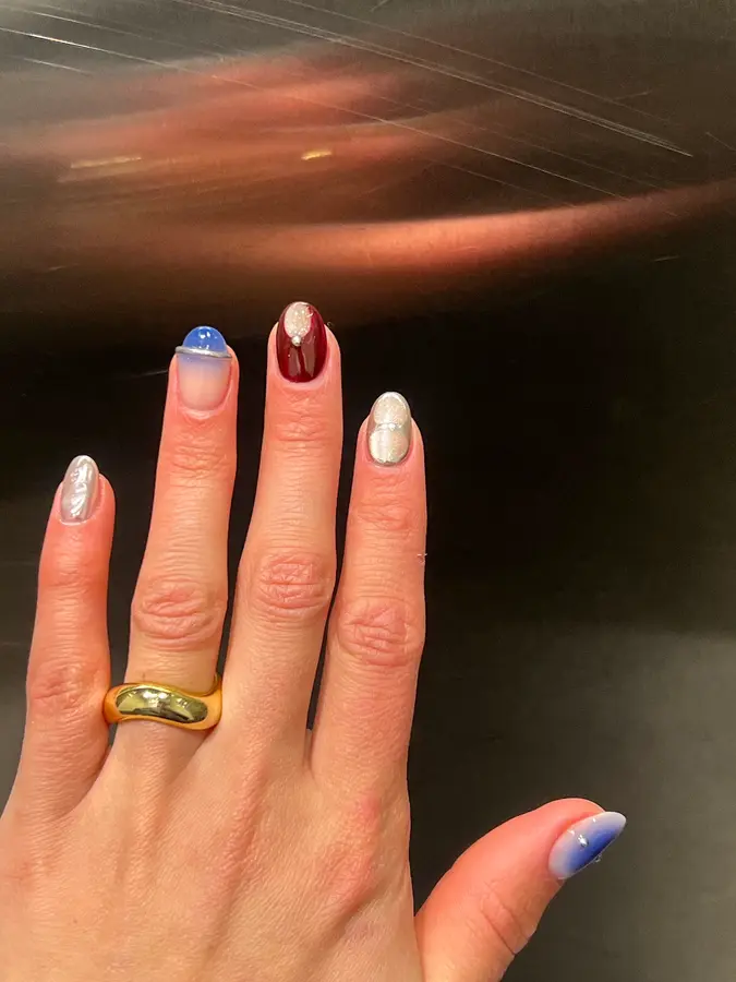 Mix aus Chrome, Kobaltblau und Bordeaux mit Steinchen auf runden Nägeln
