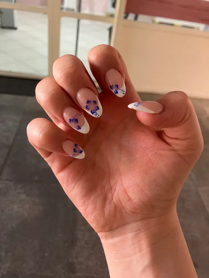 French-Nägel mit gemalten blauen Hibiskusblüten